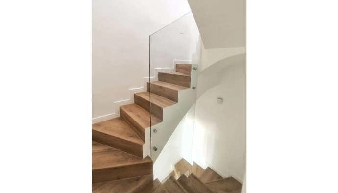 Barandilla de vidrio incoloro en una única pieza para varias alturas y soportes a pared en plata brillo