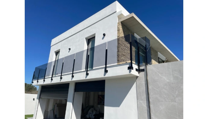 Barandilla para balcón de vivienda en vidrio gris y postes de anclaje negro mate