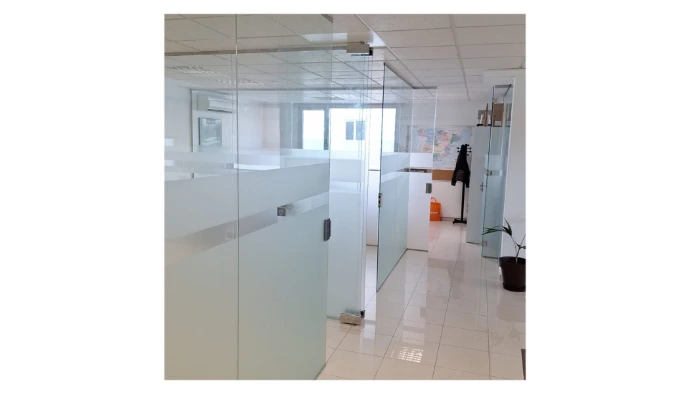 Divisoria oficina con vidrios fijos y puertas abatibles con cerradura con llave y vinilos