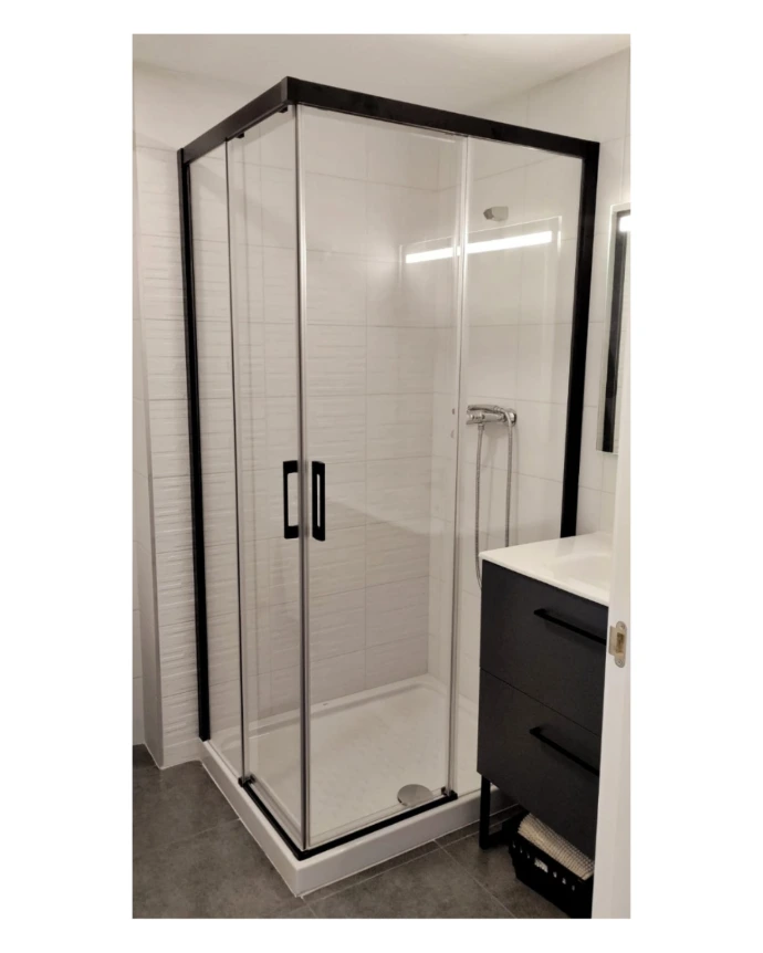 Mampara de ducha fijo y puerta corredera con perfiles en negro