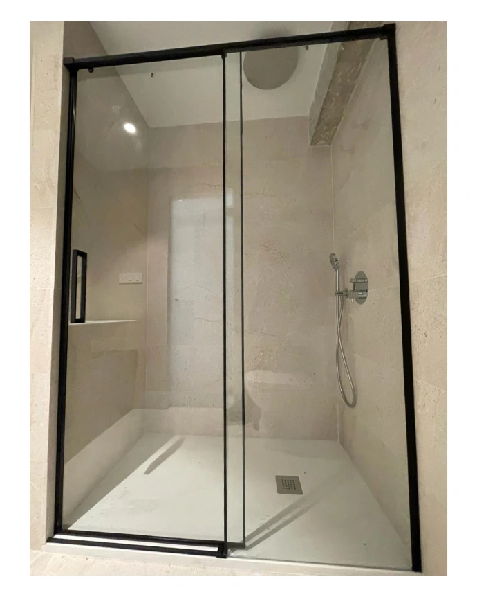 Mampara de ducha fijo y puerta corredera con perfiles en negro