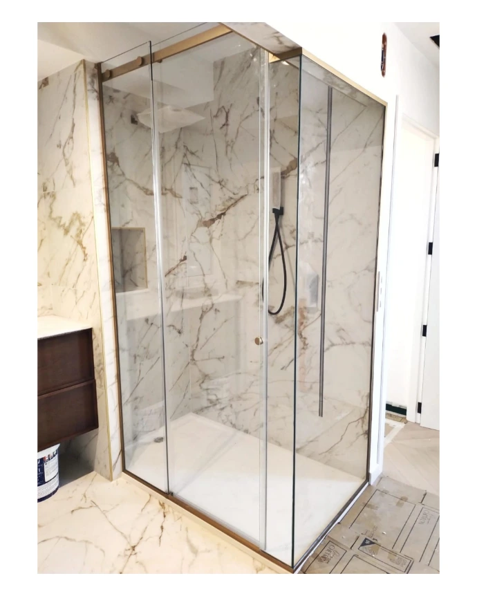 Mampara de ducha fijo y puerta corredera con perfiles en oro