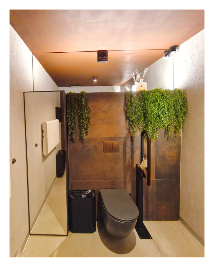 Espejos sobre pared y puerta armario en baño de cafetería