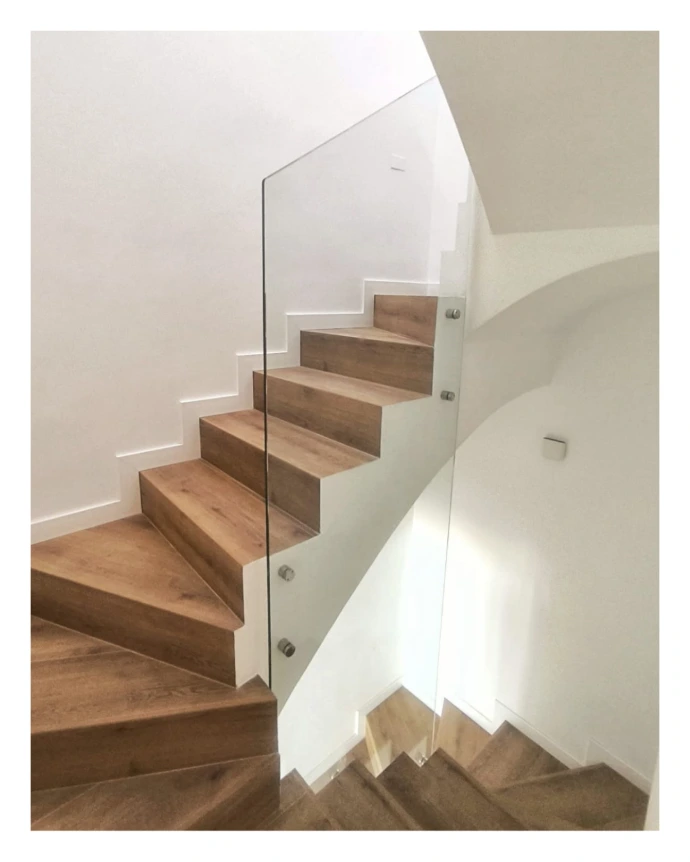 Barandilla de vidrio incoloro en una única pieza para varias alturas y soportes a pared en plata brillo