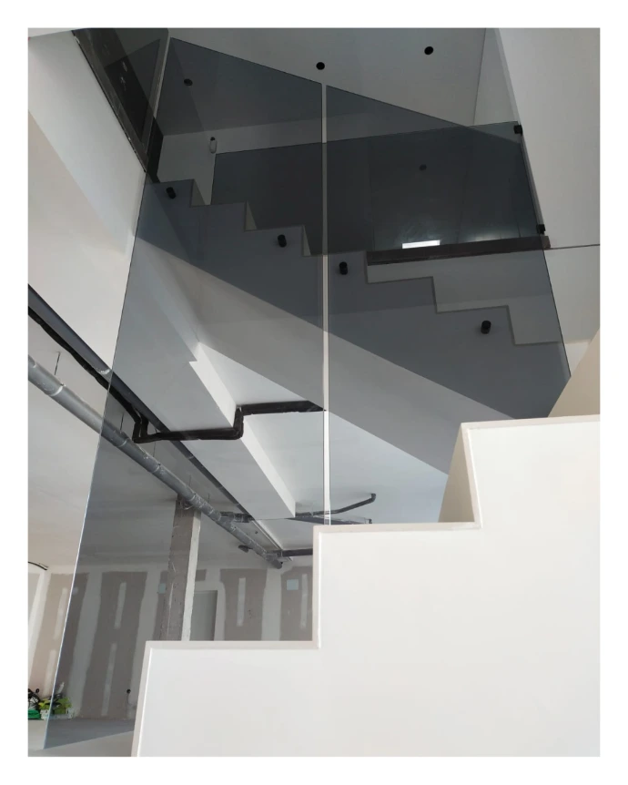 Barandilla escalera vivienda en vidrio gris y soportes en negro