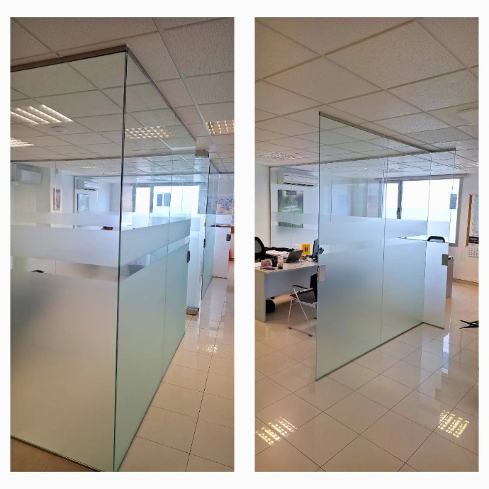Divisoria oficina con vidrios fijos y puertas abatibles con cerradura con llave y vinilos